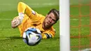 Kiper Timnas Liechtenstein, Benjamin Buchel melakukan penyelamatan saat menghadapi Portugal pada laga lanjutan Grup J Kualifikasi Euro 2024 di Rheinpark Stadium, Vaduz, Jumat (17/11/2023) dini hari WIB. (AFP/Sebastien Bozon)