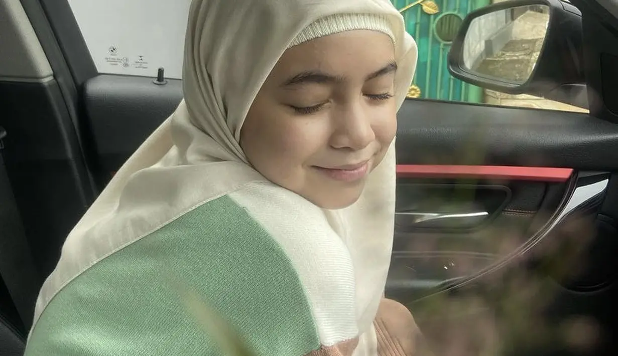 Kerudung model segi empat broken white juga dikenakan Sienna. Dipadukan cardigan dan celana cokelat pleatednya. Credit: (@nesyanabila)