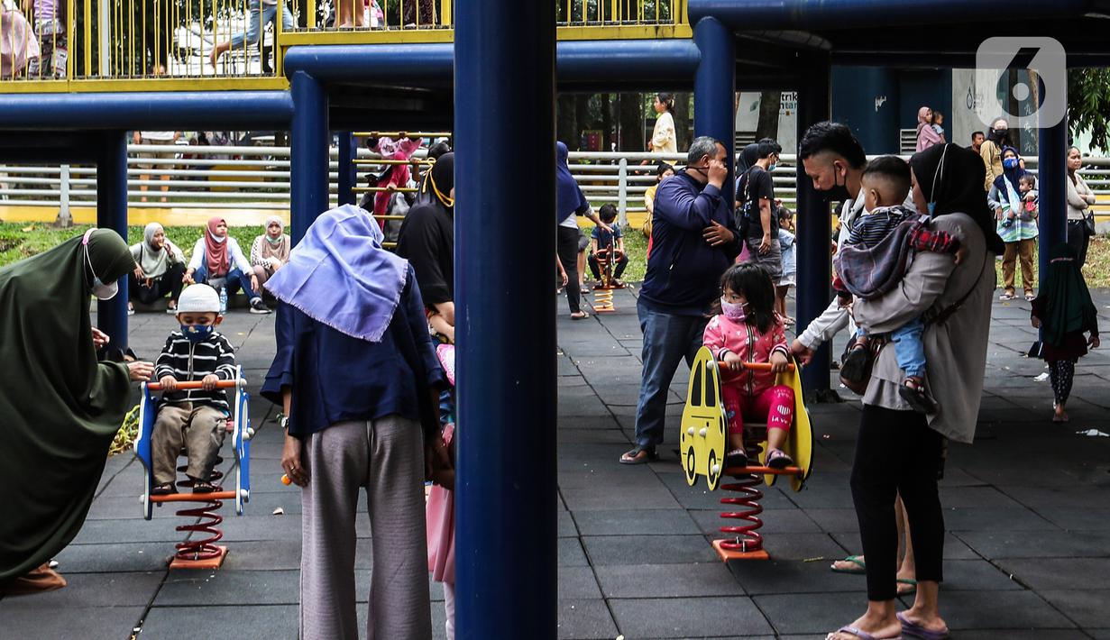 Anak-anak didampingi orang tua mereka bermain di Taman Puring, Jakarta, Minggu (9/1/2022). Di tengah ancaman penyebaran covid-19 varian Omicron dan pemberlakukan PPKM level 2, masyarakat tetap melakukan aktivitas pada akhir pekan di luar rumah. (Liputan6.com/Johan Tallo)