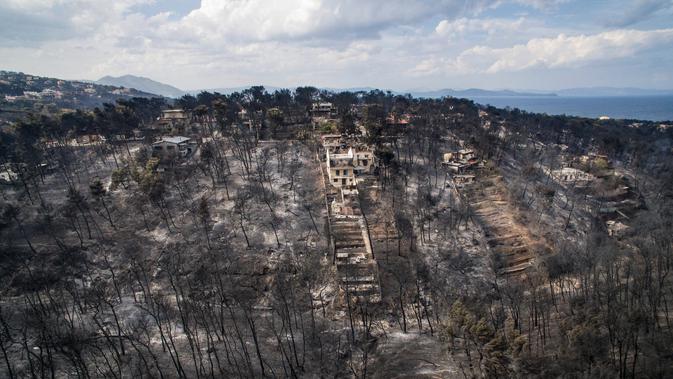 Pemandangan udara menunjukkan kerusakan yang disebabkan oleh kebakaran hebat di dekat Desa Mati, dekat Athena, Selasa (24/7). Selain menewaskan 74 orang, 170 lainnya terluka dalam kebakaran hutan tersebut. (Savas Karmaniolas/AFP)
