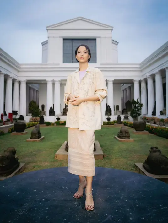 Putri Marino pilih gaya feminin sebagai tampilan bak anak perempuan kedua. Mengenakan setelan blazer dan midi skirt dari Sapto Djojokartiko dengan t-shirt lilac. [@hagaipakan]