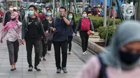 Sejumlah orang berjalan di trotoar pada saat jam pulang kantor di Kawasan Sudirman, Jakarta, Senin (8/6/2020). Aktivitas perkantoran dimulai kembali pada pekan kedua penerapan Pembatasan Sosial Berskala Besar (PSBB) transisi pandemi COVID-19. (Liputan6.com/Johan Tallo)