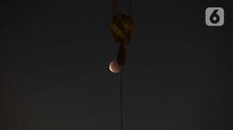 Gerhana bulan terlihat dari di Jalan Belah Kapal, Cilincing, Jakarta Utara pada Rabu (26/5/2021). Gerhana bulan yang disebut juga fenomena "Super Blood Moon" tersebut berlangsung sekitar lima jam lima menit dan dapat disaksikan dari seluruh Indonesia. (merdeka.com/Imam Buhori)