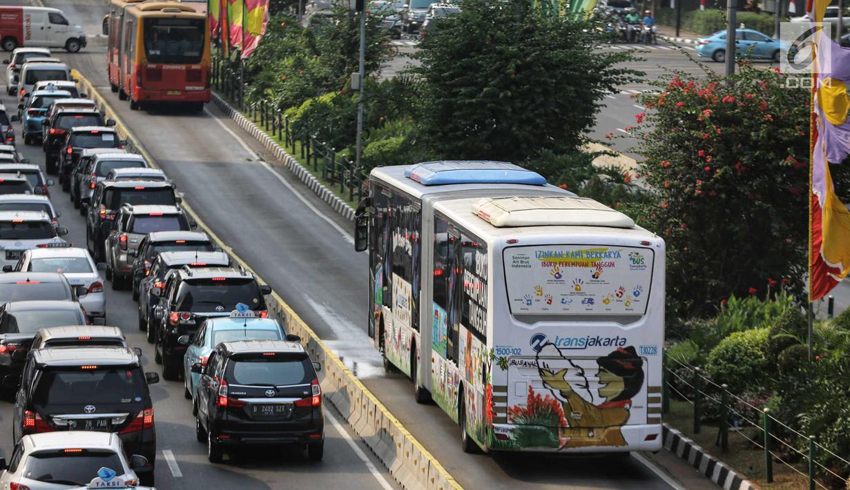 Bus Transjakarta melintas di Jalan MH Thamrin, Jakarta, Senin (24/7). Kebijakan Pemprov DKI Jakarta menggratiskan bus Transjakarta adalah untuk menyambut Asian Games 2018. (Liputan6.com/Faizal Fanani)