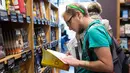 Aidan Devlon  melihat buku di toko Amazon Books di University Village, Seattle, Washington, Selasa (3/11). Setelah 20 tahun mejual buku secara online, akhirnya Amazon membuka toko buku fisik pertamanya. (AFP Photo/Jason Redmond)