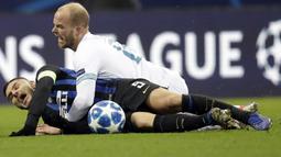 Striker Inter Milan, Mauro Icardi, terjatuh saat berebut bola dengan pemain PSV Eindhoven, Jorrit Hendrix, pada laga Liga Champions di Stadion San Siro, Italia, Selasa (11/12). Kedua tim bermain imbang 1-1. (AP/Luca Bruno)