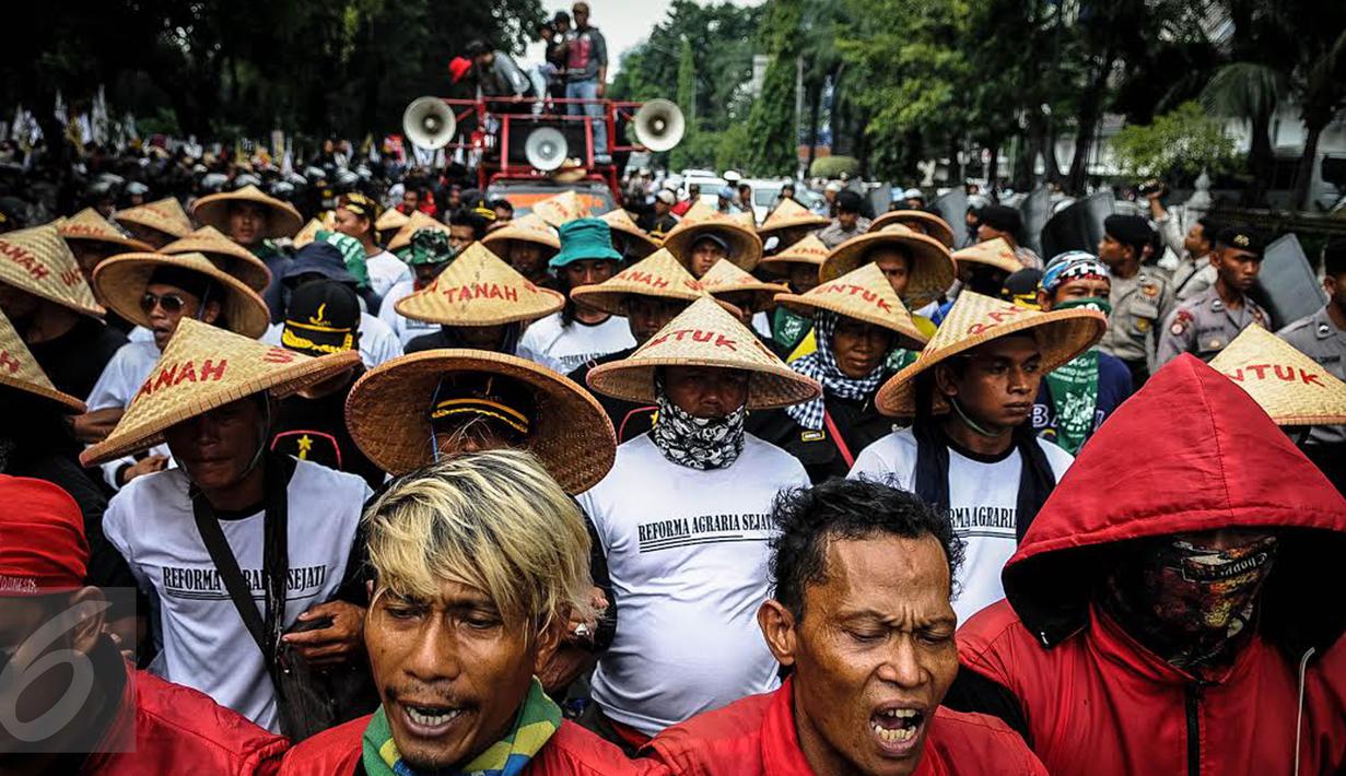 Massa yang mengatasnamakan petani dari berbagai provinsi mengenakan topi caping saat menggelar demonstrasi di kawasan Medan Merdeka, Jakarta, Selasa (27/9). Aksi tersebut digelar dalam rangka memperingati Hari Tani Nasional. (Liputan6.com/Faizal Fanani)