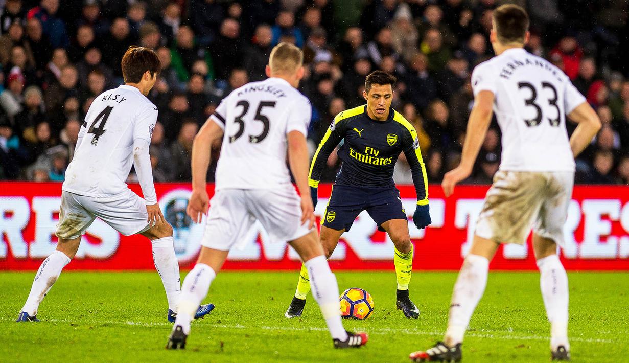 Penyerang Arsenal, Alexis Sanchez, berusaha melewati hadangan pemain Swansea. Pada laga ini kedua tim turun menggunakan formasi 4-2-3-1. (EPA/Aled Llywelyn)