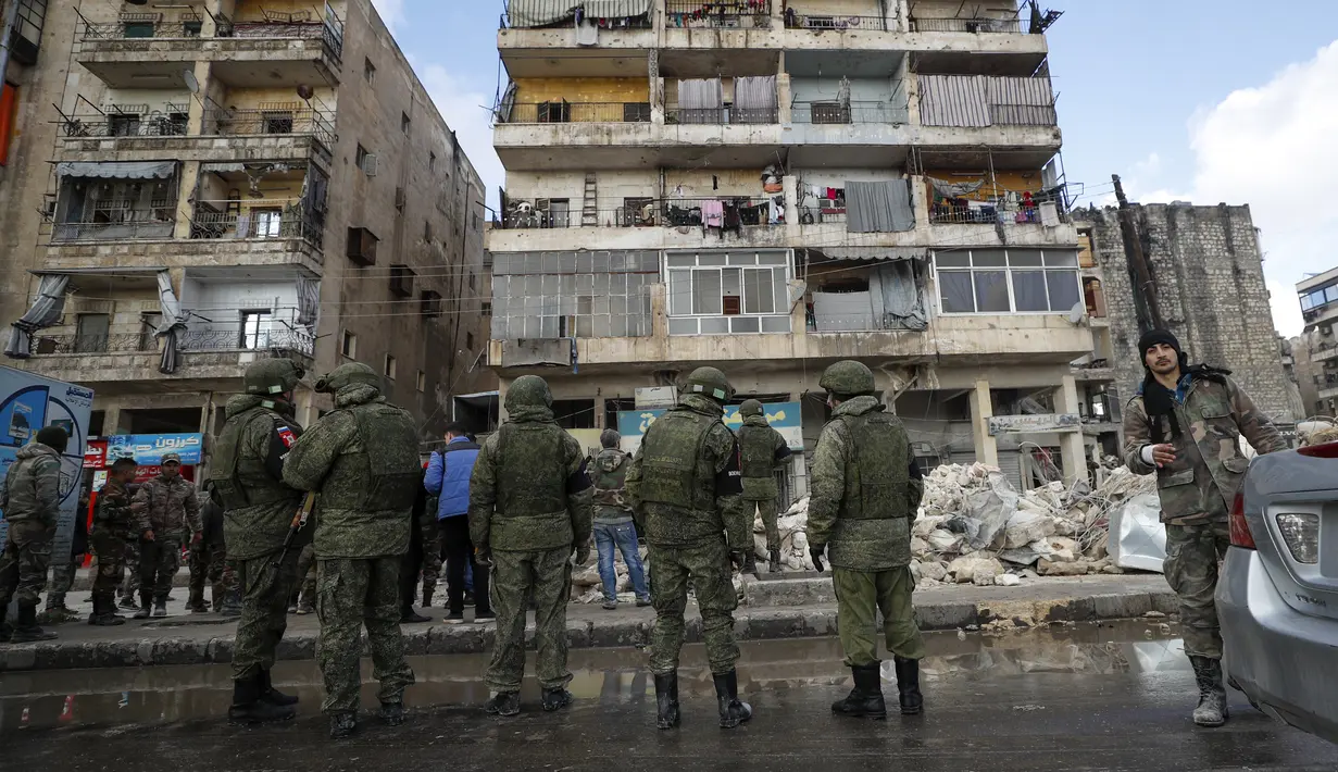 Tentara Rusia dan pasukan keamanan Suriah memeriksa puing-puing bangunan yang runtuh, di Aleppo, Suriah, Selasa, 7 Februari 2023. Tim penyelamat berlari pada Selasa untuk menemukan korban selamat di antara puing-puing ribuan bangunan yang runtuh akibat gempa kuat dan beberapa gempa susulan yang melanda Turki timur dan tetangga Suriah. (AP/Omar Sanadiki)