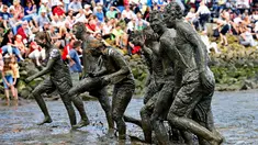 Peserta berjalan meninggalkan lapangan usai bermain bola tangan yang dinamakan "Wattoluempiade" (Olimpiade Lumpur) di Brunsbuettel, Jerman, (30/7). (REUTERS/Fabian Bimmer)