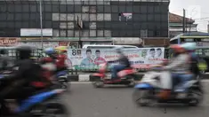 Kendaraan melintas di depan spanduk kampanye pasangan calon Wali Kota dan Wakil Wali Kota Bekasi Nur Supriyanto-Adhi Firdaus serta calon Gubernur-Wakil Gubernur Jawa Barat Ajat-Syaikhu di jalanan kota Bekasi, Minggu (24/6). (Merdeka.com/Iqbal Nugroho)