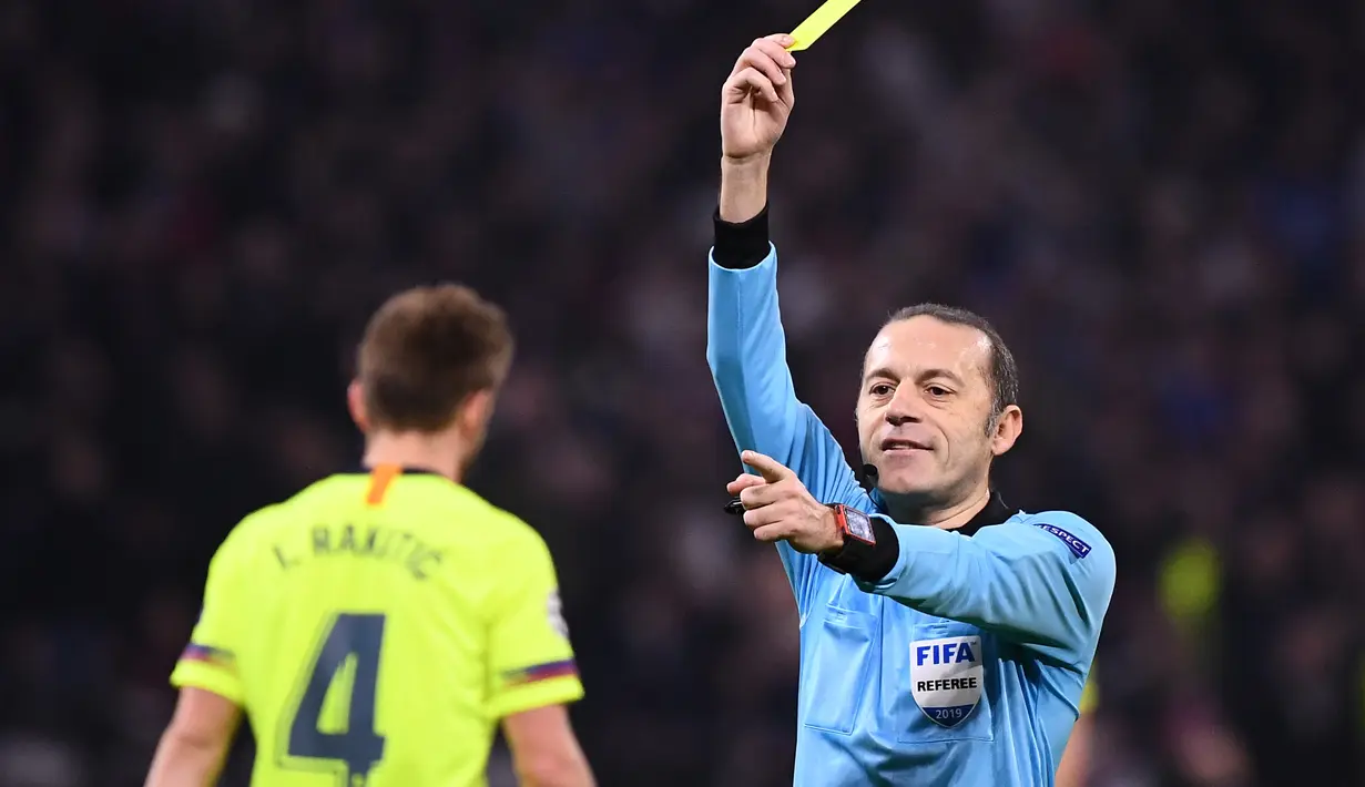 Cuneyt Cakir mengeluarkan kartu kuning untuk Ivan Rakitic pada leg 1, babak 16 besar Liga Champions yang berlangsung di stadion Parc Olympique Lyonnais, Lyon, Rabu (20/2). Barcelona bermain imbang 0-0 kontra Lyon. (AFP/Franck Fife)