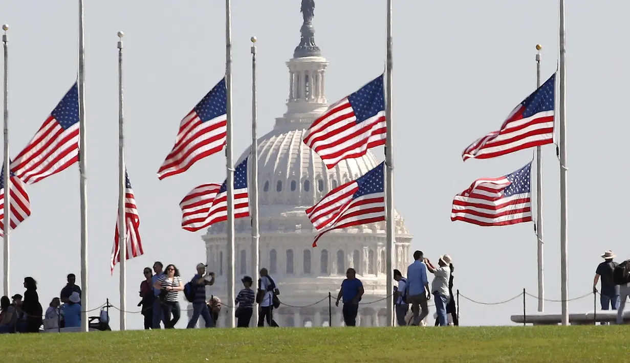 Pemandangan bendera setengah tiang di belakang gedung Capitol di Washington, DC. AS (2/10). Akibat kejadian ini sekitar 59 orang tewas dan 500 lainya terluka. (Mark Wilson/Getty Images/AFP)