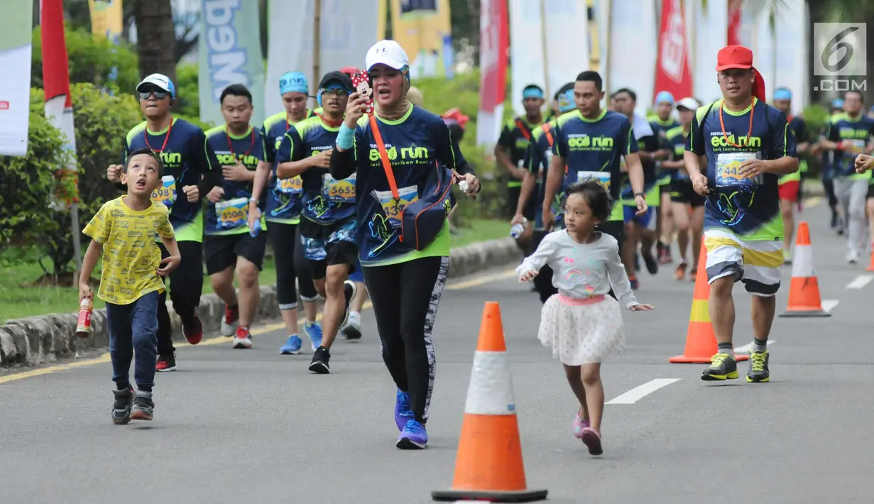 Salah satu pelari berlari sambil berkomunikasi saat lomba Pertamina Eco Run 2017 di Pantai Karnaval Ancol, Jakarta, Sabtu (16/12). Ribuan pelari ambil bagian pada lomba yang bertema Lari Lestarikan Bumi. (Liputan6.com/Helmi Fithriansyah)