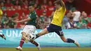 Aksi pemain Meksiko, Hirving Lozano (kiri) melepaskan tembakan melewati pemain Skotlandia, Ryan Christie pada laga uji coba di Azteca Stadium, Meksiko City, (2/6/2018). Meksiko menang 1-0. (AP/Rebecca Blackwell)