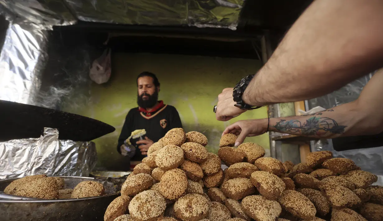 Seorang warga Palestina membuat falafel, makanan yang disukai untuk berbuka puasa, selama bulan suci Ramadhan di pusat kota kota Hebron di Tepi Barat yang diduduki (9/4/2022). Falafel adalah sebuah makanan Timur Tengah. (AFP/Hazem Bader)