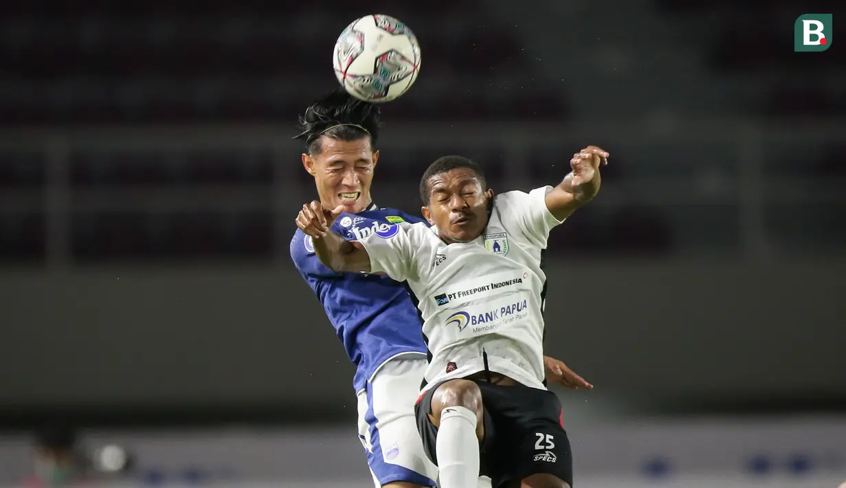 Pemain Persib Bandung, Henhen Herdiana (kiri) berduel udara dengan pemain Persipura Jayapura, Juscak Joshua Marthen Isir dalam laga pekan ke-10 BRI Liga 1 2021/2022 di Stadion Manahan, Solo, Sabtu (30/10/2021). (Bola.com/Bagaskara Lazuardi)