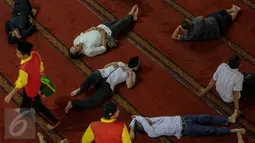 Petugas berjalan diantara warga yang tengah tertidur di Masjid Istiqlal, Jakarta, Jumat (19/6/2015). Waktu luang diisi warga dengan berbaring dan beristirahat di masjid sambil menunggu waktu berbuka puasa. (Liputan6.com/Faizal Fanani)