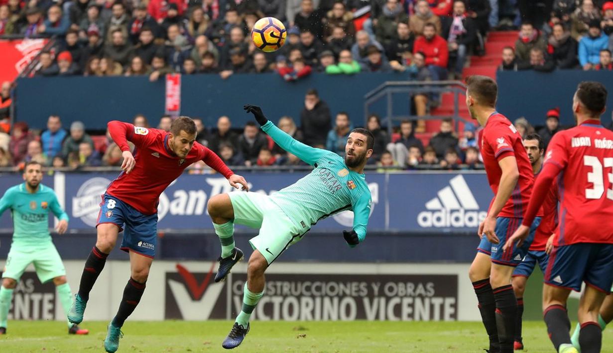 Pemain Barcelona, Arda Turan, berebut bola dengan pemain Osasuna, Goran Causic dalam laga La Liga di Stadion Reyno de Navaraa, Osasuna, Sabtu (10/12/2016). (AFP/Cesar Manso)