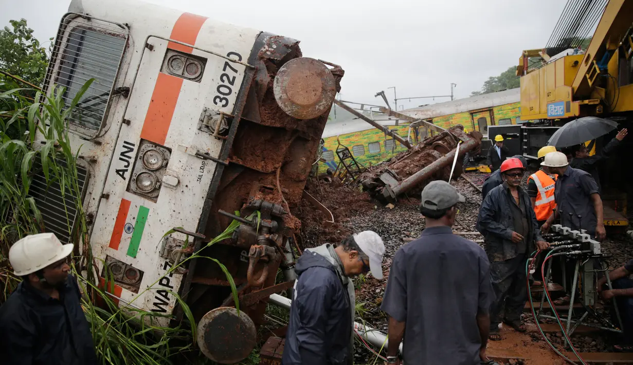 Petugas berusahan mengevakuasi kereta yang tergelincir di Asangaon, India (29/8). Sejauh ini tidak ada korban jiwa akibat kecelakaan kereta tersebut. (AP Photo / Rafiq Maqbool)