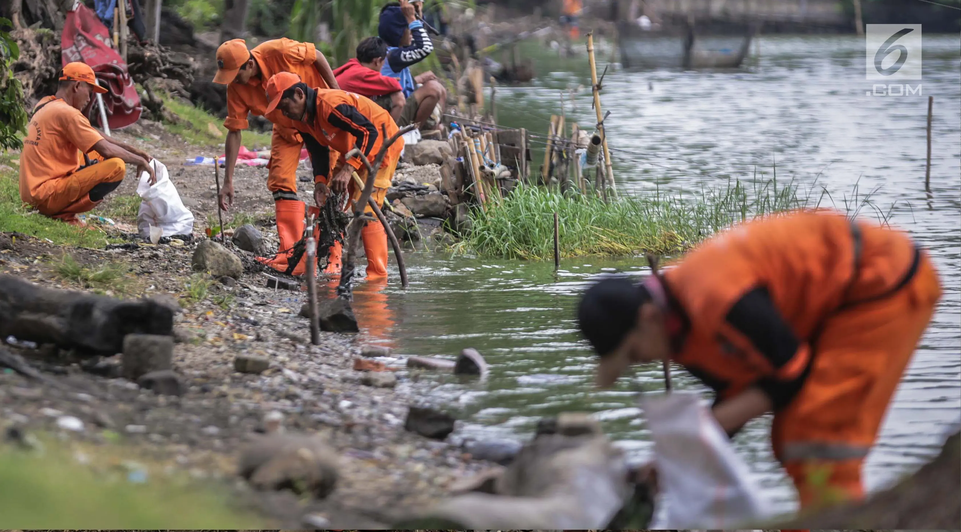 Aksi bersih-bersih yang dilakukan petugas PSSU atau pasukan oranye di pinggiran Danau Sunter, Jakarta, Rabu (27/12). Kegiatan ini dilakukan terkait rencana Pemkot Jakarta Utara menggelar perayaan tahun baru di Danau tersebut. (Liputan6.com/Faizal Fanani)