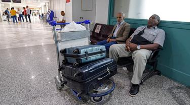 Wisatawan menunggu dengan barang bawaan mereka setelah penerbangan dibatalkan karena aksi mogok massal pekerja di Bandara Internasional Tunis-Carthage Tunisia, Kamis (16/6/2022). Serikat Pekerja Umum Tunisia (UGTT) mengadakan aksi mogok massal pada hari Kamis ini menuntut kenaikan gaji dan konsesi. (FETHI BELAID / AFP)