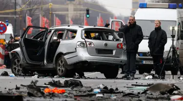 Petugas kepolisian memeriksa bangkai mobil Volkswagen yang rusak di Berlin , Jerman, (15/3). Warga Jerman di gegerkan oleh sebuah mobil yang tiba meledak di pusat kota Berlin. (REUTERS / Fabrizio Bensch)