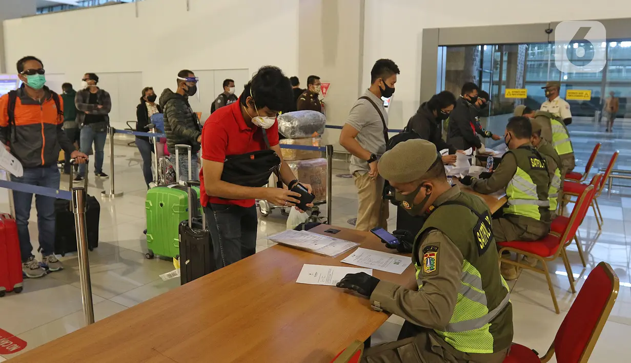 Petugas sedang mengecek SIKM di terminal 3 kedatangan domestik bandara Soekarno Hatta, Tangerang, Banten, Rabu (27/5/2020). Bandara Soetta memberlakukan Tiga checkpoint di terminal kedatangan salah satunya pemeriksaan SIKM dan doukumen kesehatan setiap penumpang. (Liputan6.com/Herman Zakharia)