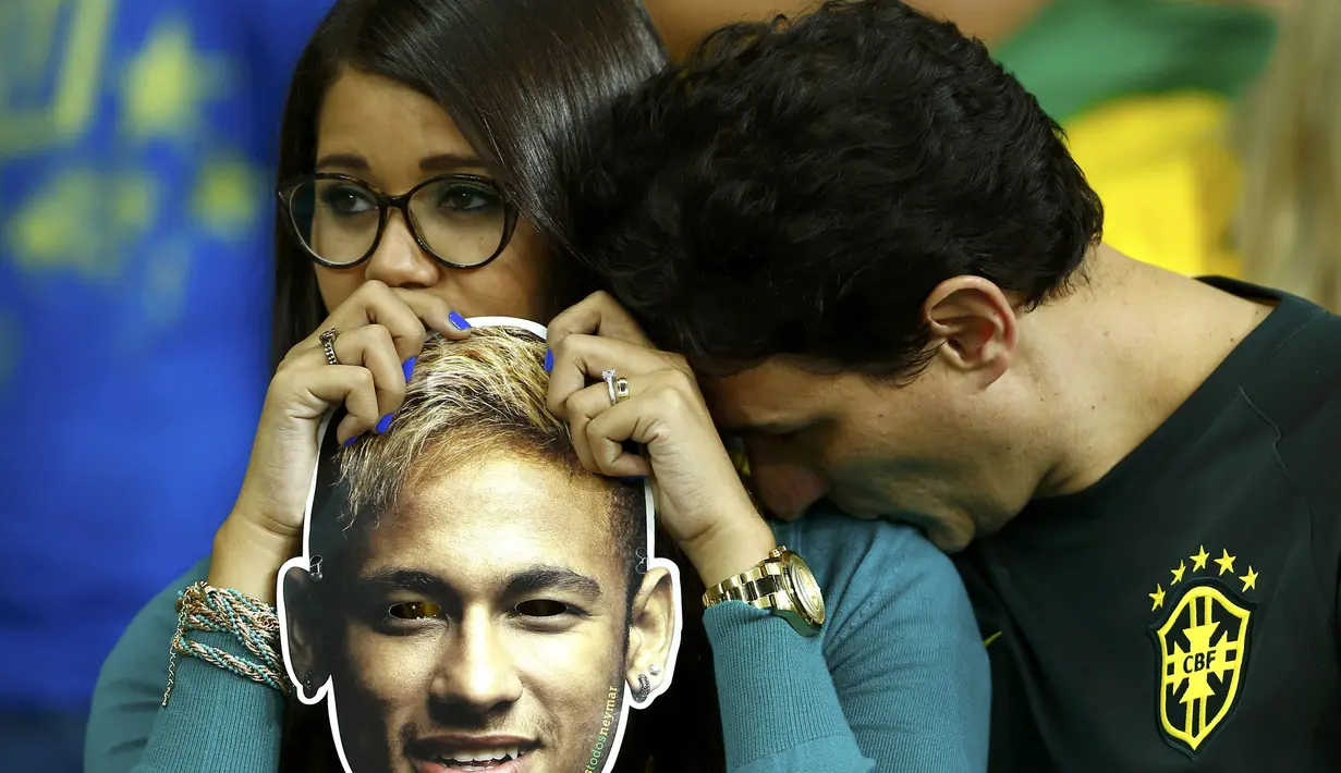 Kesedihan juga dirasakan sepasang kekasih pendukung timnas Brasil, Selasa (8/7/14). (REUTERS/Eddie Keogh)