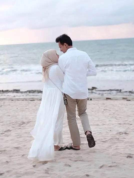 Beberapa foto yang sama juga diunggah oleh sang istri. Dalam keterangan foto saat sedang dipinggir pantai, ibu satu anak itu menceritakan tiga kali ke Bali dalam kurun dua tahun. (Instagram/fedinuril)