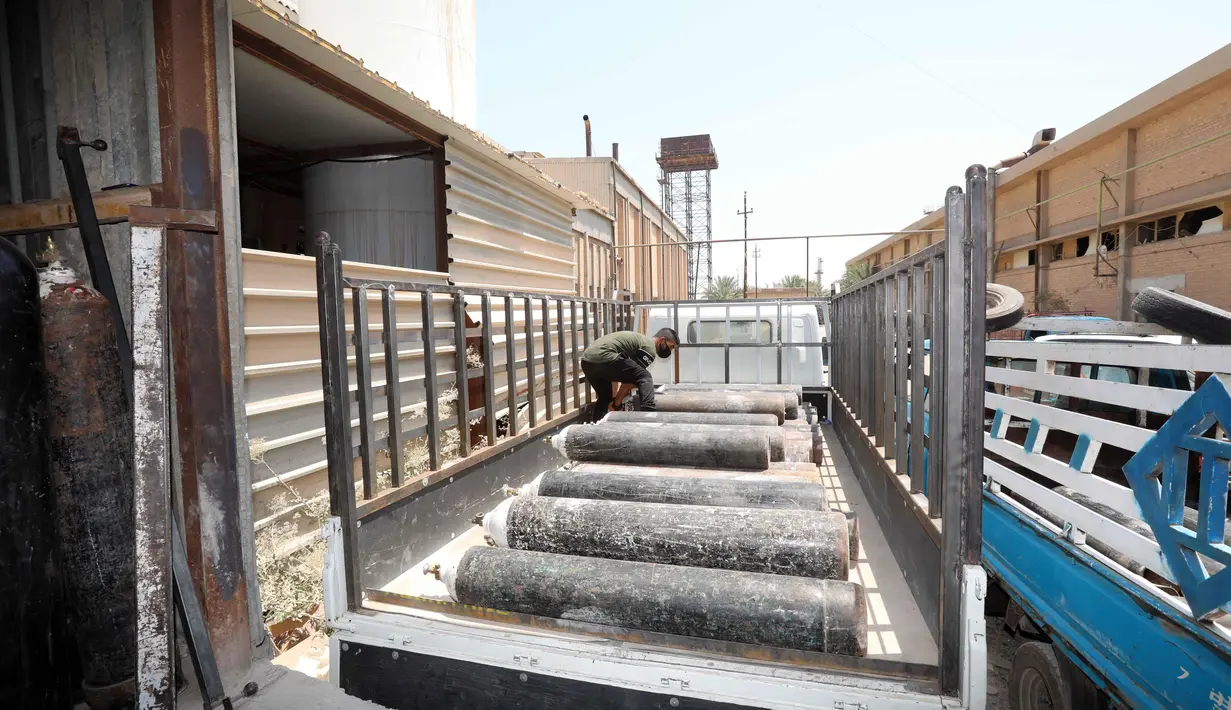 Seorang pria mengangkut beberapa tabung oksigen ke atas truk untuk dikirim ke sejumlah rumah sakit di Baghdad, Irak (7/7/2020). Pelonjakan kembali pandemi COVID-19 terus berlanjut di Irak pada Selasa (7/7) ketika Kementerian Kesehatan Irak mengonfirmasi 2.426 kasus baru. (Xinhua)