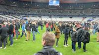 Para penonton laga Prancis versus Jerman memutuskan tetap bertahan di Stade de France, Paris, karena ada serangan bom yang terjadi di dekat lokasi tersebut pada Jumat (13/11/2015) malam waktu setempat. (AFP PHOTO / Miguel Medina)
