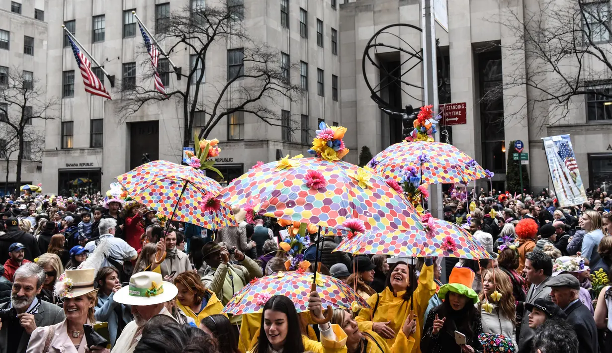 Sejumlah orang mengenakan kostum dan membawa payung saat mengikuti parade Paskah tahunan di sepanjang 5th Ave di New York City (4/1). Parade ini pun membolehkan siapa saja ikut berpartisipasi. (Stephanie Keith / Getty Images / AFP)