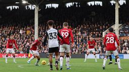 Pemain MU, Bruno Fernandes (dua kiri), berusaha mengecoh lawan sebelum mencetak gol ke gawang Fulham dalam pekan ke-11 Premier League 2023/2024 yang berlangsung di Stadion Craven Cottage, London, Sabtu (4/11/2023) malam WIB. (AFP/Adrian Dennis)