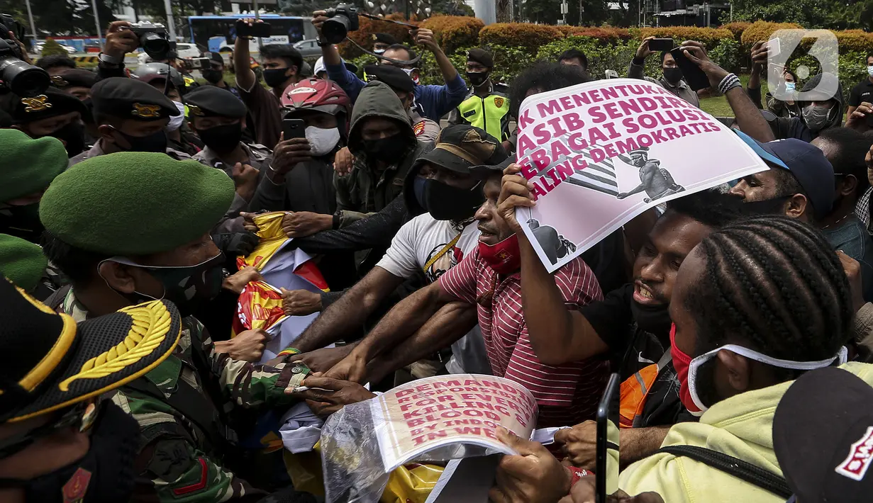 Tentara dan polisi terlibat saling dorong dengan masyarakat Papua yang memperingati Operasi Trikora 19 Desember 1961 di Patung Kuda, Jakarta, Sabtu (19/12/2020). Dalam aksinya, massa menuntut 15 isu besar. (Liputan6.com/Johan Tallo)