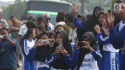 Sejumlah pelajar mengabadikan prosesi kirab kereta kencana pernikahan putri Presiden Jokowi,  Kahiyang Ayu-Bobby Nasution saat menuju Gedung Graha Saba di Surakarta, Rabu (8/11). (Liputan6.com/Angga Yuniar)