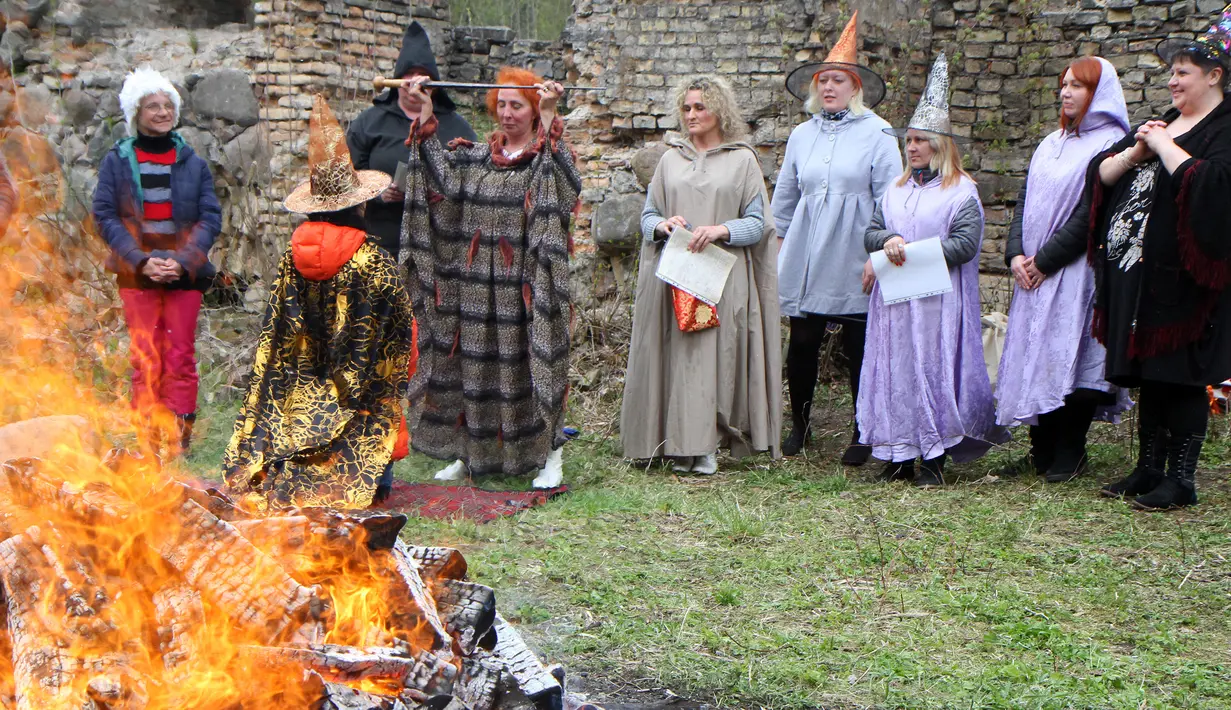 Sejumlah orang menggelar ritual sihir di acara Walpurgis Night atau Witches Night di Vilnius, Lithuania, Senin (1/5). Orang-orang yang hadir mengenakan atribut layaknya para penyihir. (AFP PHOTO / Petras Malukas)