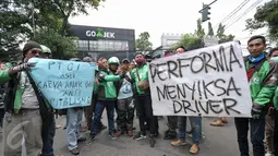 Massa driver Gojek membawa poster berisi tuntutan mereka saat berunjuk rasa di kantor PT Gojek Indonesia, Kemang, Jakarta, Senin (3/10). Driver Gojek itu menuntut agar sistem performa segera dihapus karena menyusahkan mereka. (Liputan6.com/Yoppy Renato)