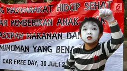 Seniman pantomim dari Dewan Kesehatan Rakyat melakukan aksi teatrikal di CFD kawasan Senayan, Jakarta, Minggu (30/07). Aksi juga menghimbau memberikan pemahaman tentang susu kental manis. (Liputan6.com/Fery Pradolo)