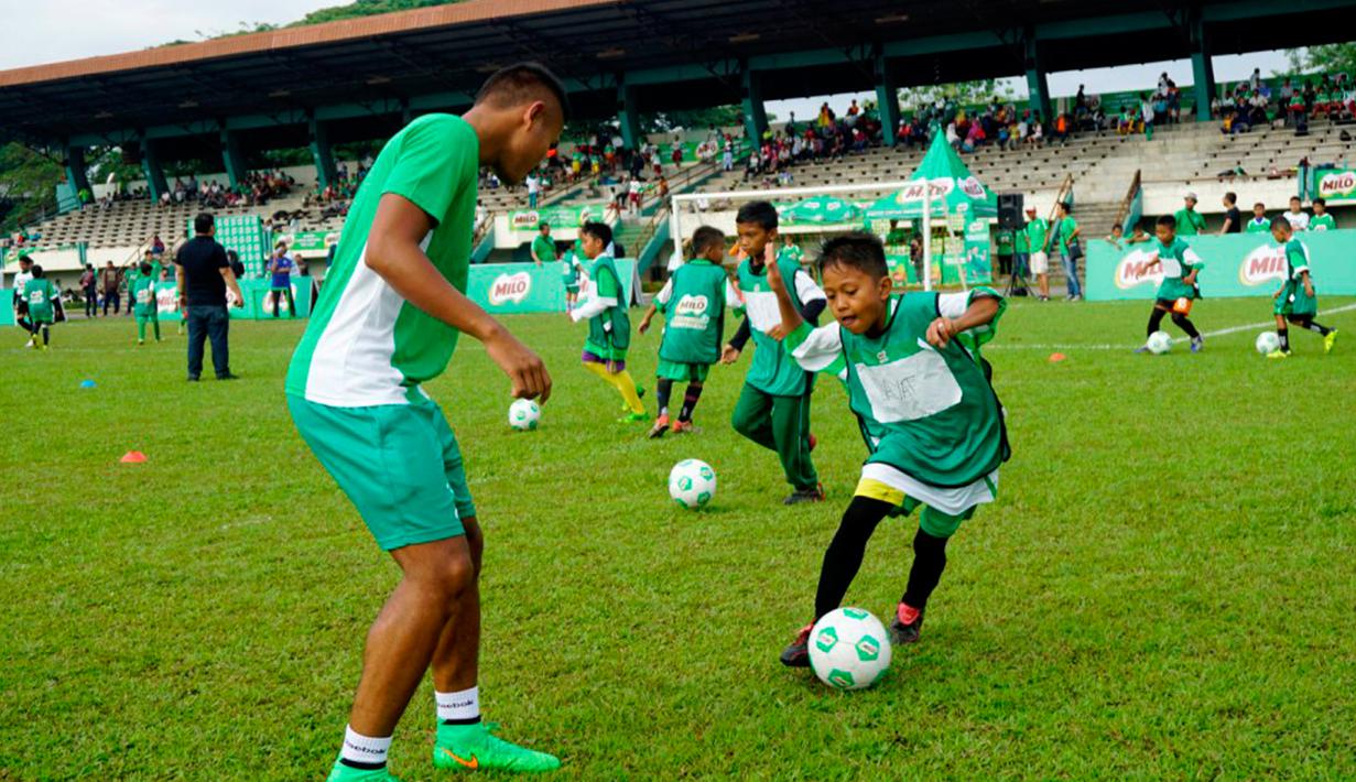 Dimas Drajad (kiri) memberikan football clinic kepada lebih dari 150 anak-anak usia sekolah dasar di stadion Mini Universitas Sumut, Minggu (14/2/2016). Football clinic merupakan salah satu kegiatan di MILO Football Championship 2016. (Foto:Istimewa)