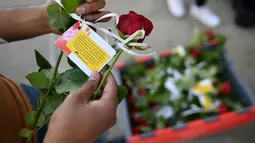 Warga membaca pesan yang tertulis dari bunga tanda bela sungkawa atas tragedi di jembatan London, Inggris (11/6). Serangan teror itu menyebabkan 7 orang tewas. (AFP PHOTO / Ben STANSALL)