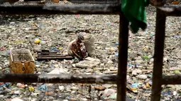 Teresita Gapayao (51) mengais sampah yang masih dapat difungsikan di aliran Sungai Estero de Vitas di Tondo, Manila, Filipina, Kamis (21/4). Teresita sudah 12 tahun menafkahi keluarganya dari sampah-sampah yang bisa di daur ulang. (Noel CELIS/AFP)