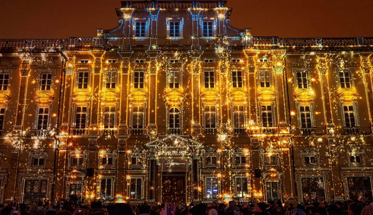 Orang-orang mengambil gambar Museum Seni Rupa yang diterangi selama Festival of Lights (Fete des Lumieres) di kota Lyon, Prancis, Kamis (5/12/2019). Festival yang digelar sejak tahun 1852 ini berlangsung, bertepatan dengan musim liburan Natal. (ROMAIN LAFABREGUE / AFP)