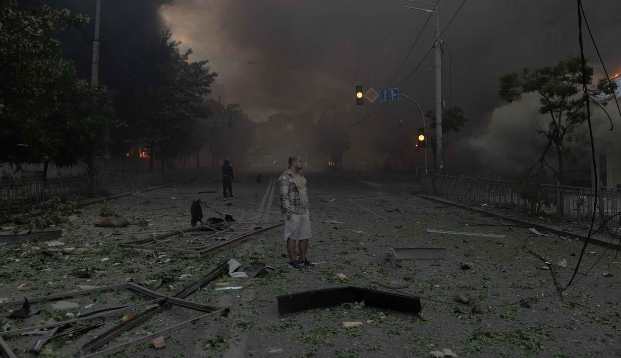 Seorang pria berdiri di tengah kepulan asap dan melihat bangunan-bangunan yang rusak parah akibat serangan Rusia di Kyiv pada Minggu 24 Mei 2026, di tengah invasi Rusia ke Ukraina. (Roman PILIPEY/AFP)
