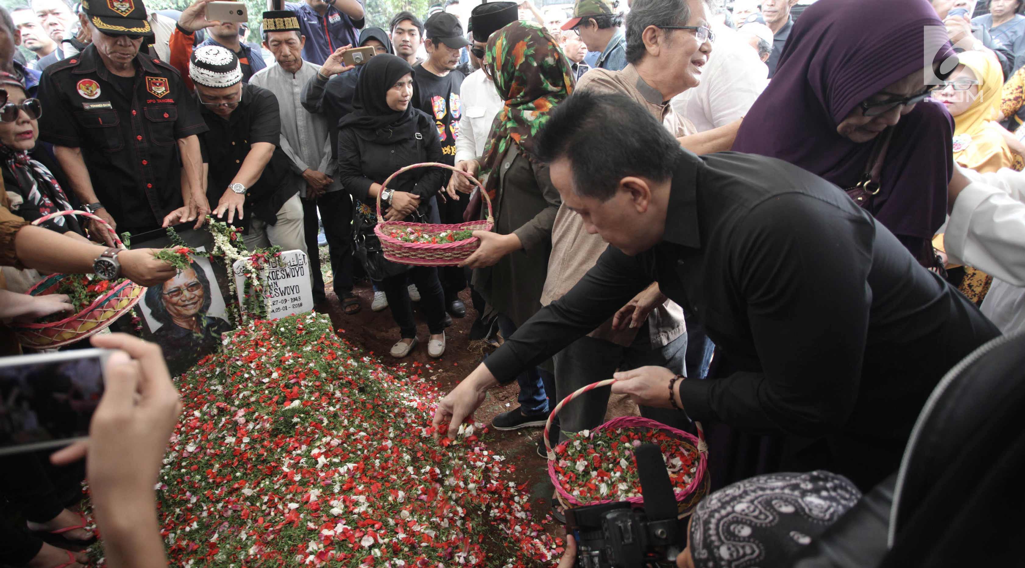 Keluarga dan kerabat menaburkan bunga di atas makam Yon Koeswoyo di TPU Tanah Kusir, Jakarta Selatan, Sabtu (6/1).   Yon Koeswoyo meninggal dunia pada usianya yang ke-77 tahun karena menderita sakit komplikasi. (Liputan6.com/Arya Manggala)