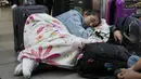 Penumpang maskapai Viva Air tidur di bandara setelah maskapai berbiaya rendah itu menangguhkan operasinya di Bandara Internasional El Dorado di Bogota, Kolombia, Selasa (28/2/2023). Viva Air, di situs webnya, "dengan menyesal mengumumkan penangguhan operasinya, karena keterlambatan dalam definisi aliansi yang tepat waktu yang akan memungkinkan integrasinya dengan grup maskapai yang lebih kuat dan lebih besar." (AP Photo/Fernando Vergara)