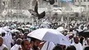 Para jamaah Muslim berjalan di sepanjang kompleks Masjidil Haram di bawah kipas kabut air yang dipasang di kota suci Mekah pada Minggu 24 Mei 2026, menjelang ibadah haji tahunan. (Zain JAAFAR/AFP)