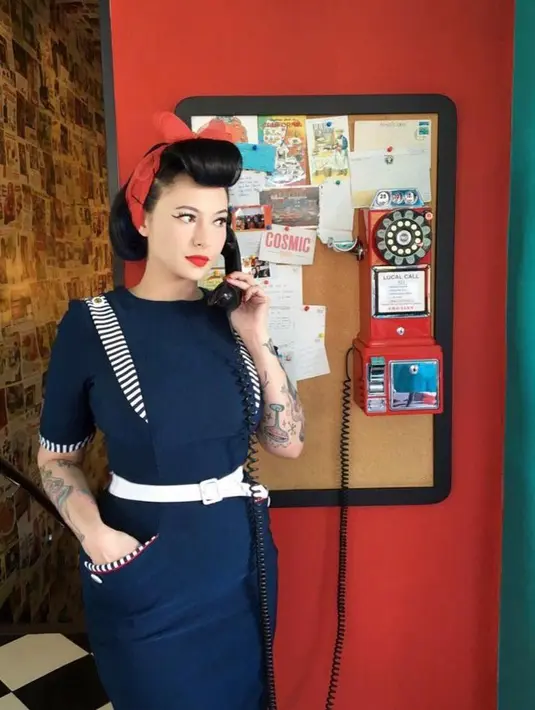 Gaya chic Claudia memadukan stewardess uniform dengan belt putih dan bandana warna merah. (Instagram/miss_adinda_mae).