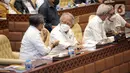 Menteri Pekerjaan Umum dan Perumahan Rakyat (PUPR) Basuki Hadimuljono (kedua kiri) berbincang saat mengikuti rapat kerja bersama Komisi V DPR RI di Kompleks Parlemen, Senayan, Jakarta, Selasa (17/1/2023). Rapat tersebut membahas tentang pembahasan program-program Kementerian PUPR tahun 2023 dan evaluasi pelaksanaan anggaran tahun 2022. (Liputan6.com/Faizal Fanani)