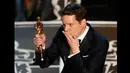 Penulis Graham Moore menerima piala Oscar untuk skenario terbaik dalam film "The Imitation Game" selama 87 Academy Awards di Dolby Theatre, Los Angeles, California, (22/2/2015). (Reuters/Mike Blake)